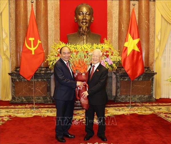 Chủ tịch nước Nguyễn Xuân Phúc tặng hoa Tổng Bí thư Nguyễn Phú Trọng, nguyên Chủ tịch nước. Ảnh: TTXVN