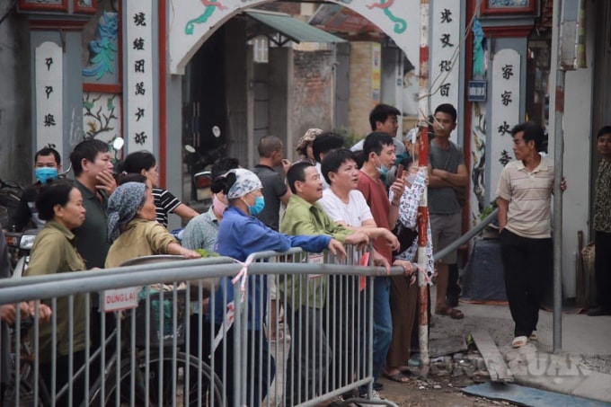 Phía ngoài barie, nhiều người dân hiếu kỳ đã đến xem, bàn tán về
