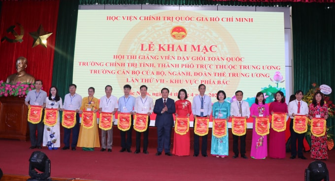 Đồng chí Nguyễn Xuân Thắng, Ủy viên Bộ Chính trị, Giám đốc Học viện Chính trị Quốc gia Hồ chí Minh trao cờ lưu niệm cho các đoàn thi