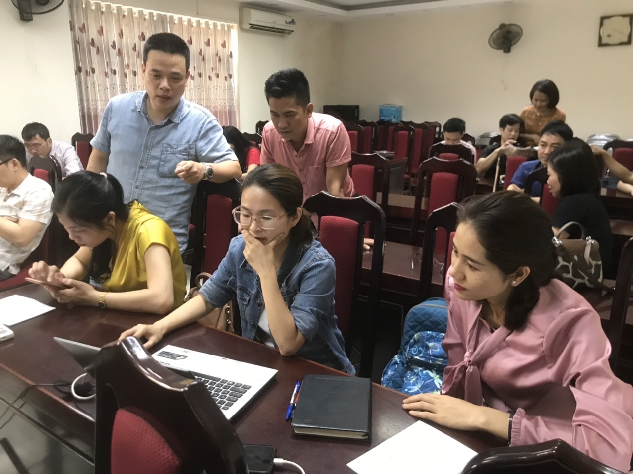 Nhà báo – họa sĩ thiết kế Trần Việt Anh hướng dẫn đồng nghiệp sử dụng các phần mềm đồ họa thiết kế E-magazine. Ảnh: NVCC