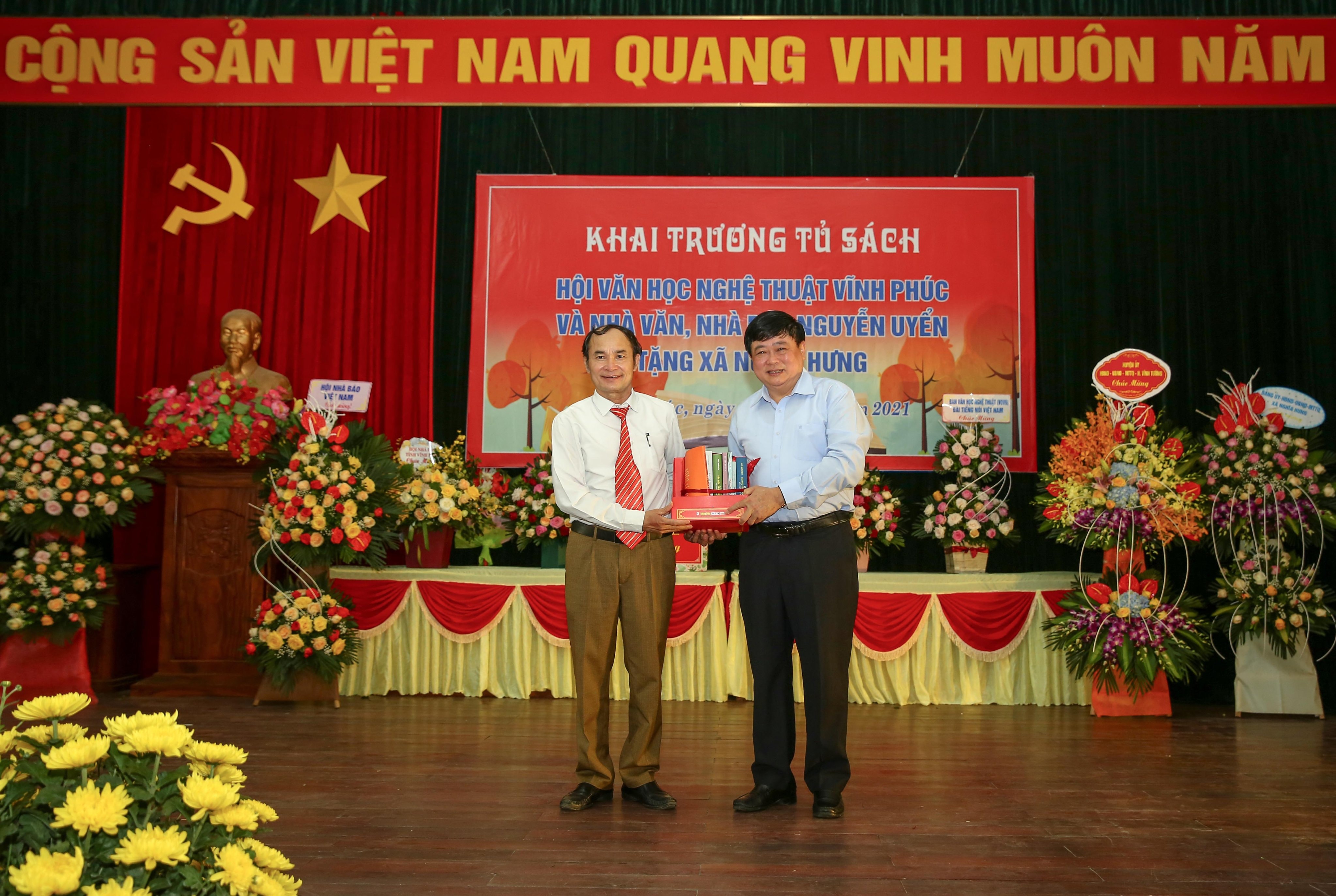 Tổng Giám đốc Đài Tiếng nói Việt Nam, Chủ tịch Hội đồng Lý luận Văn học Nghệ thuật Trung ương Nguyễn Thế Kỷ tặng sách cho cán bộ và nhân dân xã Nghĩa Hưng. Ảnh: Sơn Hải