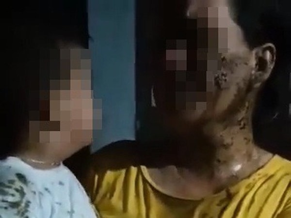 Người mẹ và cháu bé 2 tuổi bị đổ chất xú uế. Ảnh cắt từ clip