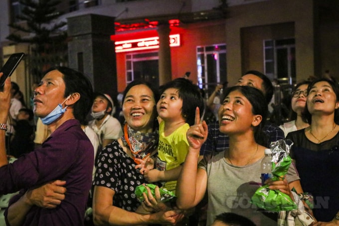 Người già, trẻ nhỏ với những nụ cười rạng rỡ chiêm ngưỡng chùm pháo hoa trên cao.