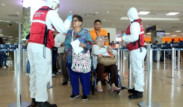 Nhân viên y tế kiểm tra thân nhiệt của hành khách tại sân bay quốc tế Mariscal Sucre ở Quito, Ecuador. Ảnh: AFP