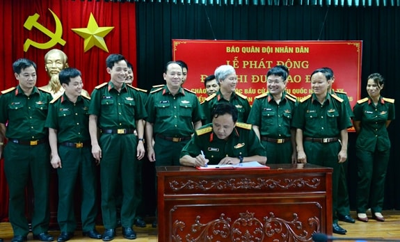 Các đồng chí trong Đảng ủy, Ban Biên tập và chỉ huy các phòng, ban ký kết giao ước thi đua. Ảnh: Phạm Hưng