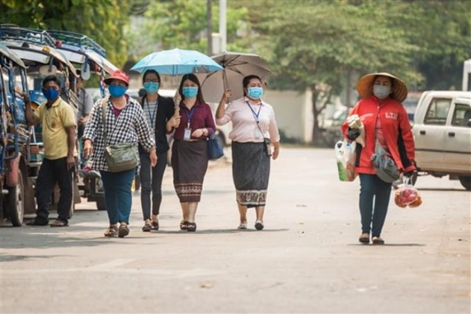Người dân đeo khẩu trang phòng lây nhiễm Covid-19 tại Vientiane, Lào. Ảnh: THX/