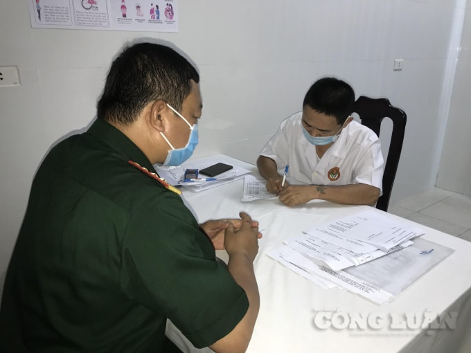 Nhân viên y tế làm thủ tục trước khi tiêm vắc xin