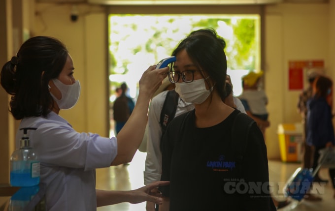 Tại khu vực trước cửa ra vào bến xe Giáp Bát, các nhận viên kiểm tra thân nhiệt, khẩu trang người dân.