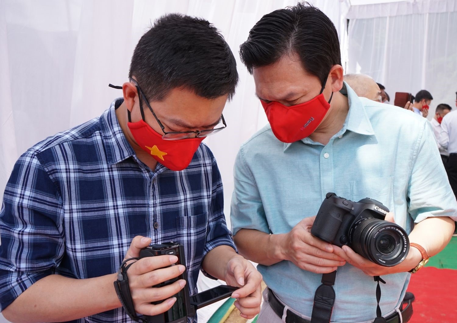 Nhà báo Huy Lê (bên trái) trao đổi với đồng nghiệp trong quá trình tác nghiệp. Ảnh: NVCC