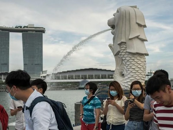 Khách du lịch đi bộ ở công viên Merlion, Singapore. Ảnh: AFP