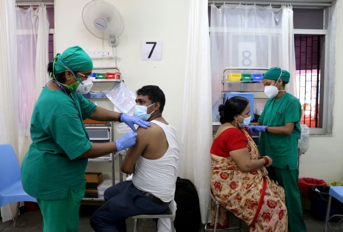 Rohit Gupta, 27 tuổi và Nandani Gupta, 42 tuổi, nhận được liều đầu tiên của họ vắc xin COVISHIELD, do Viện Huyết thanh của Ấn Độ sản xuất, tại một trung tâm tiêm chủng ở Mumbai, Ấn Độ, ngày 3 tháng 5 năm 2021 - Ảnh: REUTERS / Niharika Kulkarni