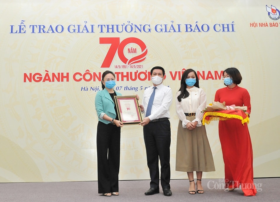 Bộ trưởng Bộ Công Thương Nguyễn Hồng Diên trao giải Đặc biệt cho đại diện nhóm tác giả Xuân Dung, Linh Thuỷ - VTV1, Ban Thời sự, Đài truyền hình Việt Nam. Ảnh: PV