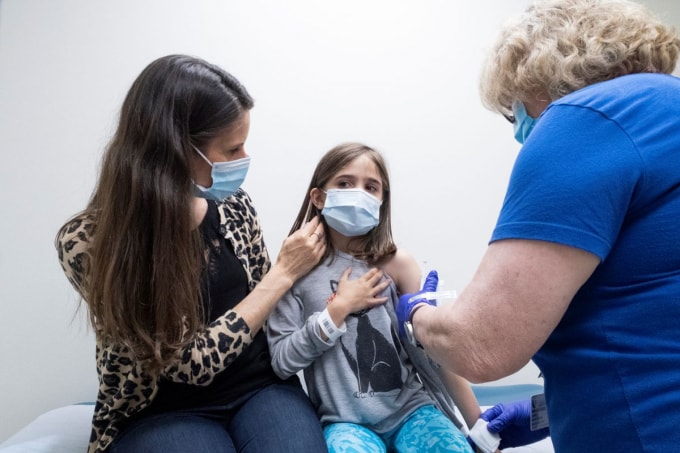 Marisol Gerardo, 9 tuổi, được mẹ bế khi tiêm liều thứ hai của vắc-xin Pfizer (COVID-19) trong một thử nghiệm lâm sàng cho trẻ em tại Duke Health ở Durham, Bắc Carolina, Hoa Kỳ, ngày 12 tháng 4 năm 2021. @ REUTERS