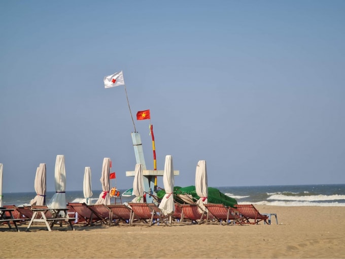 Ghế và ô che nắng nằm phơi mình trên bãi biển...chờ khách. Ảnh: M.Anh