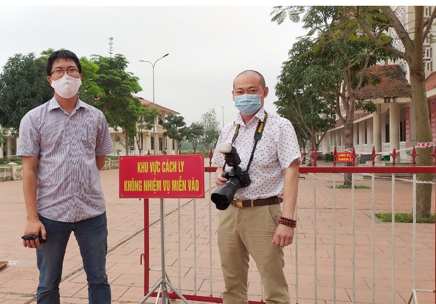 Nhà báo Nguyễn Thành Chung (phải) phóng viên Báo Nghệ An tác nghiệp ở một khu vực cách ly. Ảnh: NVCC