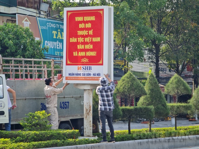 Các công nhân gấp rút đặt các pa nô, áp phích, treo băng rôn ở những tuyến đường chính