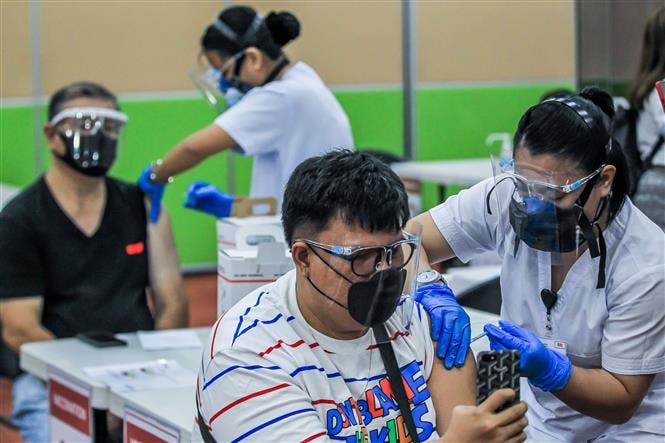 Nhân viên y tế tiêm vaccine phòng COVID-19 cho người dân tại Manila, Philippines. Ảnh: THX
