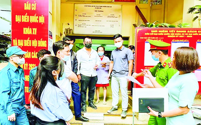 Kiểm tra công tác phòng, chống dịch Covid-19 tại nơi niêm yết danh sách cử tri phường Hàng Bạc (quận Hoàn Kiếm). Ảnh: Đặng Giang