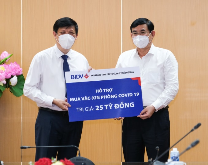 Chủ tịch Hội đồng quản trị Ngân hàng BIDV trao biểnbiển hỗ trợ mua vắc xin phòng COVID -19 số tiền 25 tỷ đồng.