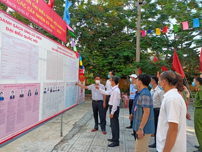 Các cử tri có mặt tại điểm bỏ phiếu sớm để xem xét kĩ lưỡng về các ứng viên.