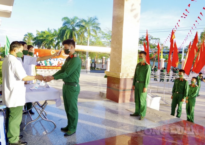Cử tri được kiểm tra thân nhiệt và sát khuẩn trước khi vào khu vực bỏ phiếu