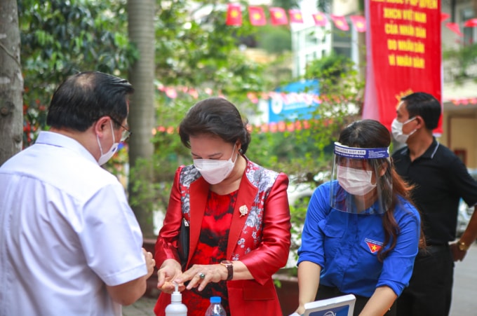 Các đồng chí lãnh đạo và cử tri được kiểm tra y tế, đo thân nhiệt, sát khuẩn trước khi vào khu vực bỏ phiếu