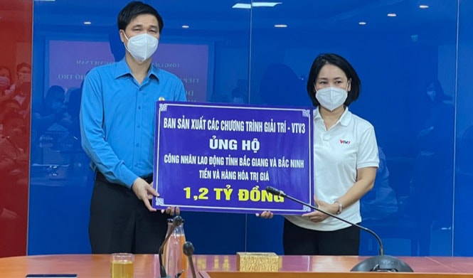 Nhà báo Tạ Bích Loan - Trưởng ban Sản xuất các chương trình Giải trí VTV3, Đài Truyền hình Việt Nam trao tiền ủng hộ công nhân, lao động bị ảnh hưởng bởi dịch Covid-19 trên địa bàn hai tỉnh Bắc Giang và Bắc Ninh. Ảnh: Hà Phong