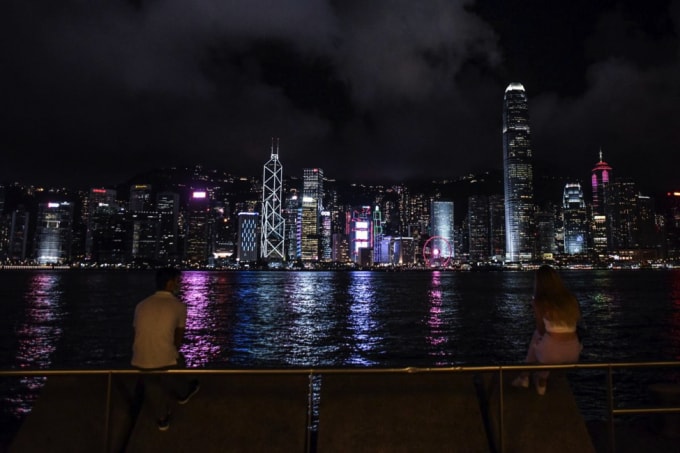 Mọi người ngắm nhìn đường chân trời qua Cảng Victoria từ bờ sông Tsim Sha Tsui ở Hồng Kông.