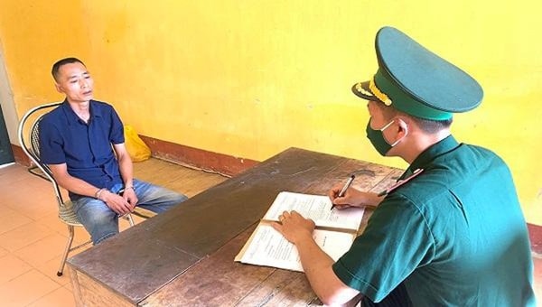 Cán bộ đồn Biên phòng cửa khẩu Trà Lĩnh lấy lời khai đối tượng Lê Quang Quân. Ảnh: PLVN