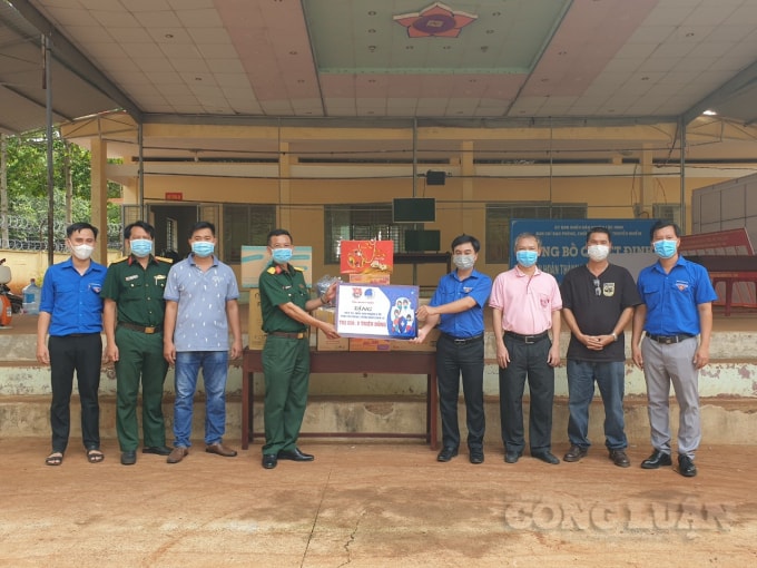 Ông Trần Quốc Duy (thứ 4 từ trái sang) trao bảng tượng trưng các nguồn lực hỗ trợ khu cách ly tập trung tại trường THPT Lộc Ninh (cũ)