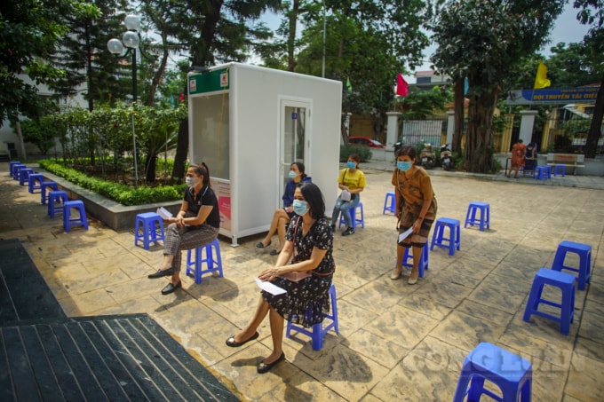 Các cán bộ coi thi chờ lấy mẫu xét nghiệm.