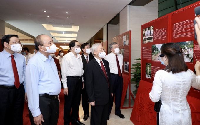 Tổng Bí thư Nguyễn Phú Trọng, Chủ tịch nước Nguyễn Xuân Phúc và các đại biểu tham quan, nghe giới thiệu Triển lãm “Những tấm gương bình dị mà cao quý”.
