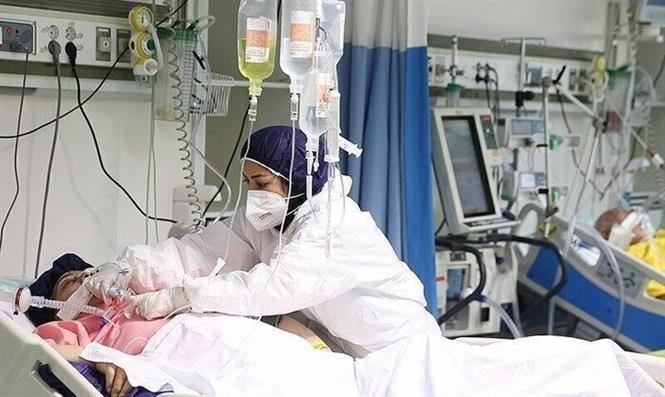 Nhân viên y tế điều trị cho bệnh nhân COVID-19 tại bệnh viện ở Iran. Ảnh: IRNA