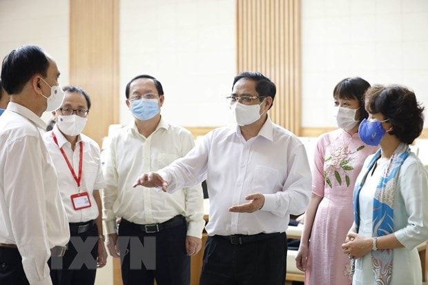 Thủ tướng Phạm Minh Chính trao đổi với đại diện các đơn vị nghiên cứu, sản xuất vaccine phòng COVID-19 trong nước. Ảnh: TTXVN