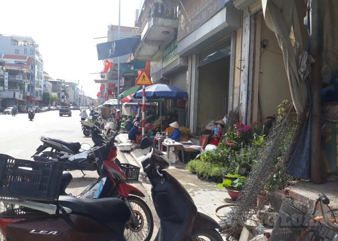 Người dân bày hàng hóa tràn ra cả vỉa hè tại mặt trước chợ Giếng Đáy, rất cần chính quyền địa phương lập lại trật tự để đảm bảo mỹ quan đô thị, an toàn giao tông. Ảnh: Nguyễn Quân.
