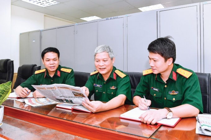 Nhóm phóng viên Báo Quân đội nhân dân trao đổi nội dung thể hiện loạt bài viết, từ phải sang trái: Trung tá Hồ Quang Phương, Đại tá Đỗ Phú Thọ, Trung tá Nguyễn Chiến Thắng. Ảnh: Tuấn Huy
