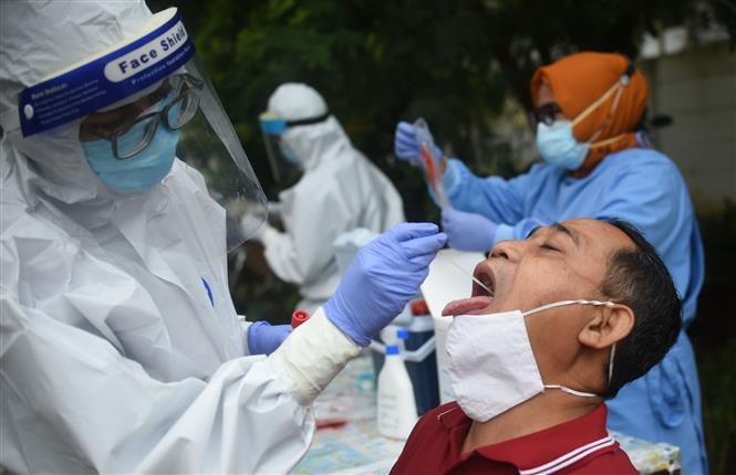 Nhân viên y tế lấy mẫu xét nghiệm COVID-19 cho người dân Indonesia. Ảnh: THX