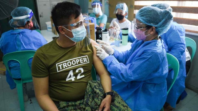 Một sĩ quan cảnh sát tiêm vắc xin CoronaVac đầu tiên của Sinovac Biotech tại Cảng cá Navotas, thuộc thành phố Navotas của Philippines, vào ngày 10 tháng 6 - Ảnh: Reuters