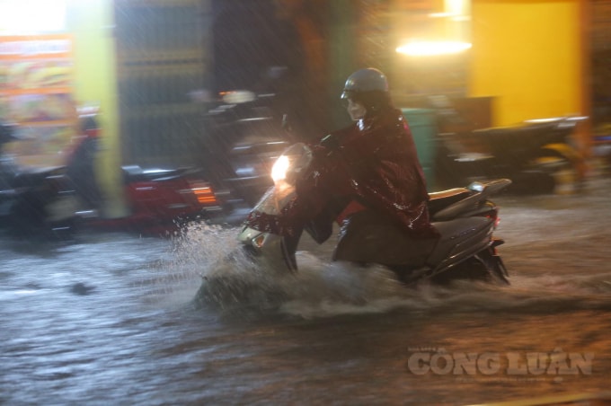 Nước ngập tới quá nửa bánh xe. (Ảnh: Quang Hùng)