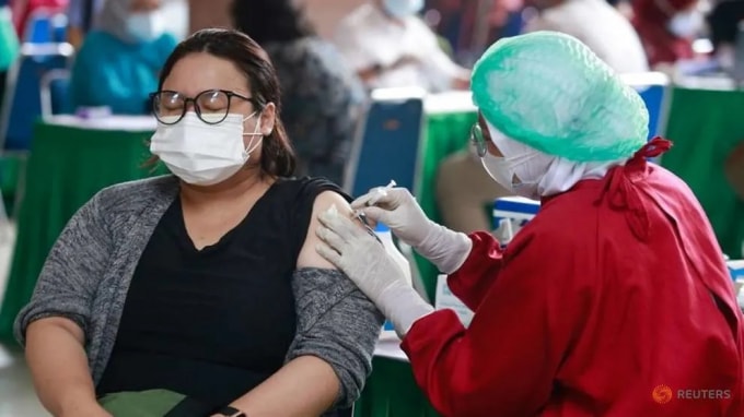 Một phụ nữ phản nhận một liều vắc-xin phòng bệnh coronavirus (COVID-19) trong chương trình tiêm chủng hàng loạt tại Trung tâm Chính quyền Thành phố Tangerang, ở Tangerang, ngoại ô Jakarta, Indonesia, ngày 30 tháng 6 năm 2021. @ REUTERS / Ajeng Dinar Ulfiana