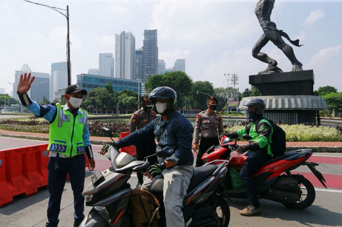 Cảnh sát Indonesia chặn xe máy di chuyển tại thủ đô Jakarta - Ảnh: Reuters