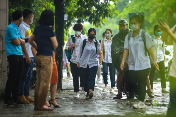 Mặc dù có mưa bất chợt, nhưng 4 thầy cô giáo của trường THPT Hà Thành (Phạm văn Đồng, Bắc Từ Liêm, Hà Nội) vẫn chịu khó đến đây từ rất sớm, đứng chờ từng em học sinh trường mình đi đến điểm thi để được ôm, bắt tay tiếp thêm động lực, năng lượng tinh thần cho các học sinh trường mình thi tốt.