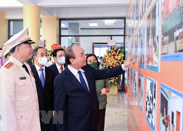 Chủ tịch nước Nguyễn Xuân Phúc tham quan trưng bày ảnh về các hoạt động của lực lượng An ninh nhân dân. Ảnh: TTXVN