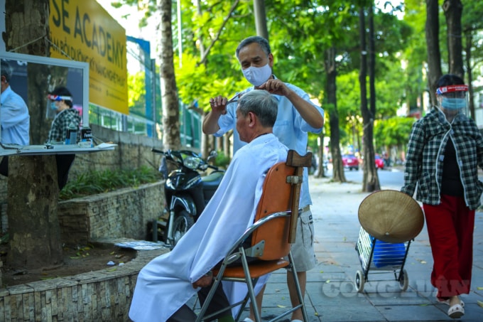Các quán cắt tóc vỉa hè chiều nay cũng đông khách.