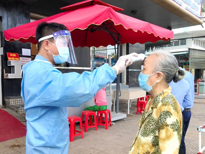 Nhân viên bệnh viện thực hiện đo thân nhiệt, sát khuẩn cho người dân đến khám chữa bệnh.