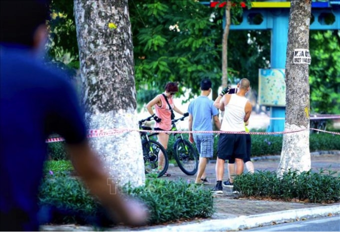 Một số người dân không đeo khẩu trang, tập thể dục khu vực ven hồ Thiền Quang. (Ảnh: Hoàng Hiếu/TTXVN).