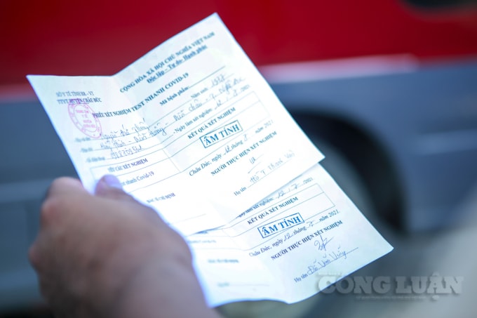 Người dân trình giấy xét nghiệm test nhanh COVID có kết quả âm tính để được di chuyển vào thành phố Hà Nội.