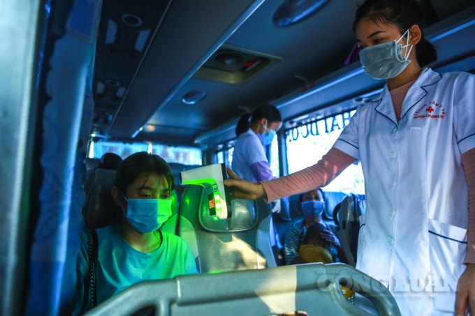 Kiểm tra thân nhiệt các hành khách trên xe khách.