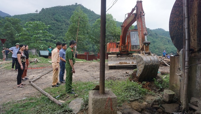 Đoàn kiểm tra của huyện Bá Thước dùng máy múc đào bới để kiểm tra các cơ sở có chôn đường ống ngầm để xả thải ra sông Mã. Ảnh: MH
