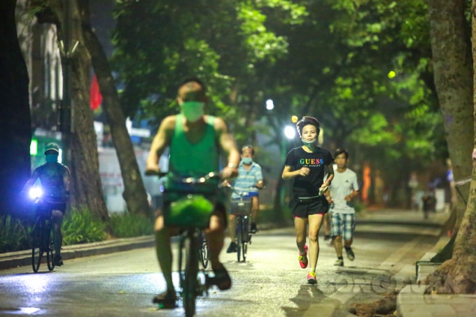 Trong ảnh, một người chạy tập thể dục không đeo khẩu trang đúng cách, còn người phía sau không đeo.